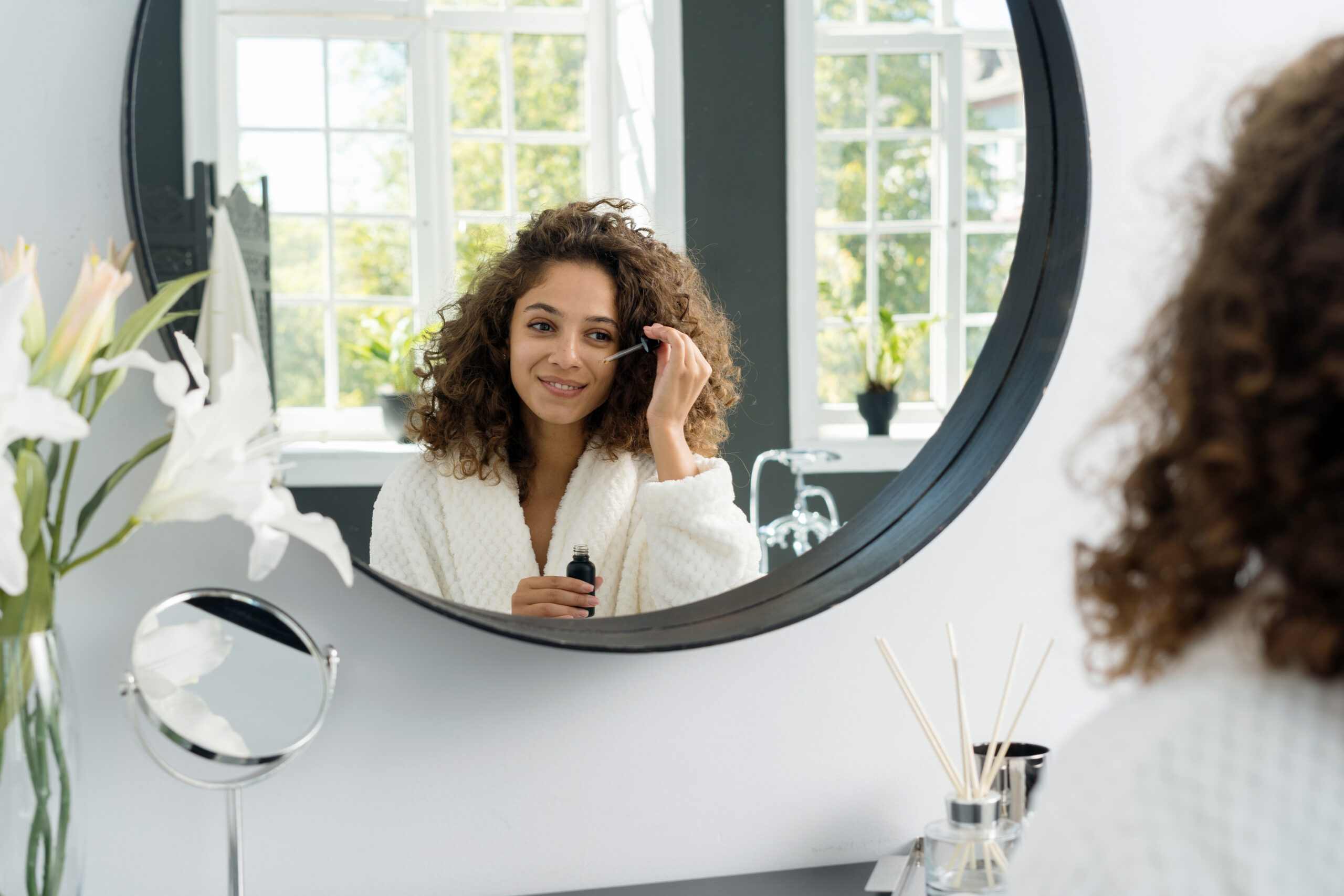 鏡の前で美容液を塗る女性